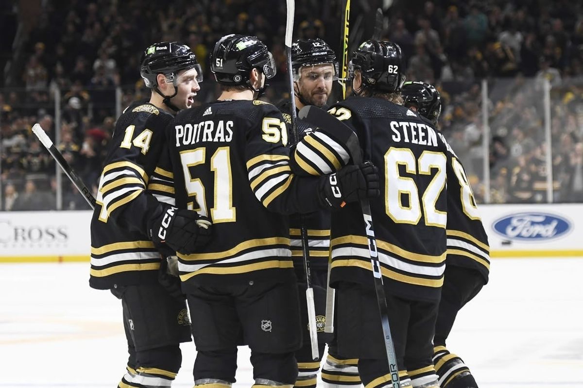 Dec 9, 2023; Boston, Massachusetts, USA;  Boston Bruins defenseman Ian Mitchell (14) center Matthew Poitras (51) center Oskar Steen (62) and defenseman Kevin Shattenkirk (12) celebrate after a goal by right wing David Pastrnak (88) against the Arizona Coyotes during the first period at TD Garden.