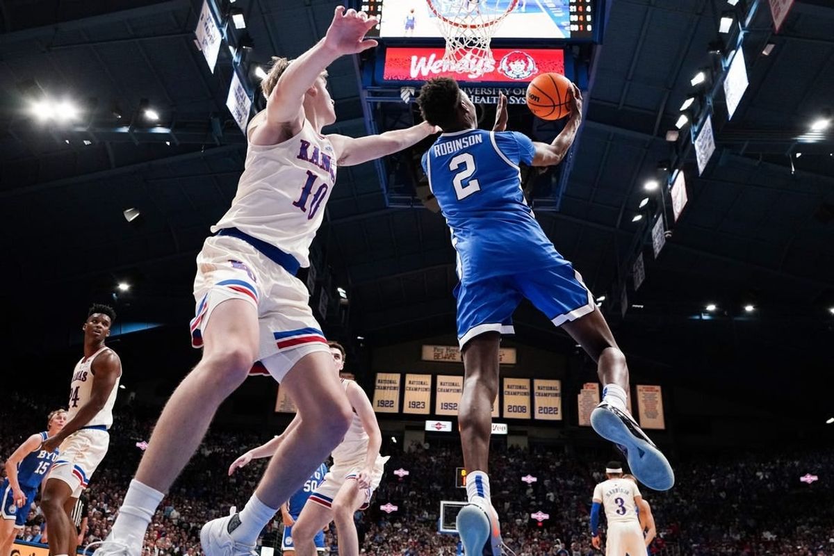 Feb 27, 2024; Lawrence, Kansas, USA; Brigham Young Cougars guard Jaxson Robinson (2) shoots as Kansas Jayhawks guard Johnny Furphy (10) defends during the second half at Allen Fieldhouse.