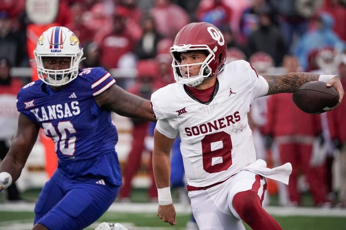 Oct 28, 2023; Lawrence, Kansas, USA; Oklahoma Sooners quarterback Dillon Gabriel (8) runs the ball as Kansas Jayhawks linebacker Rich Miller (30) defends during the game at David Booth Kansas Memorial Stadium.