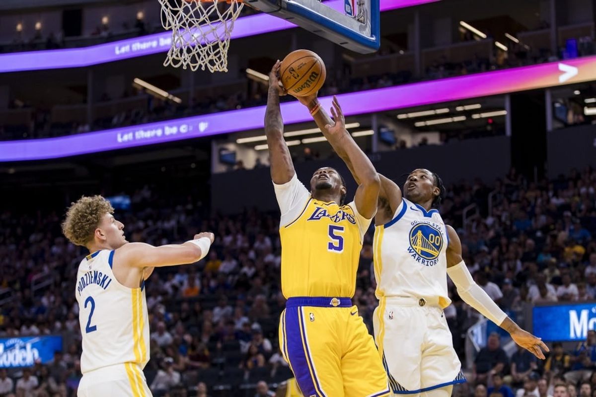 Oct 7, 2023; San Francisco, California, USA; Golden State Warriors guard Brandin Podziemski (2) and forward Jonathan Kuminga (00) defend Los Angeles Lakers forward Cam Reddish (5) during the first half at Chase Center.