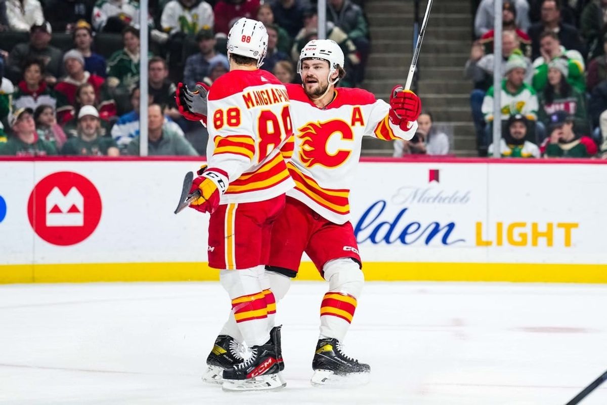 Jan 2, 2024; Saint Paul, Minnesota, USA; Calgary Flames left wing Andrew Mangiapane (88) celebrates his goal with Rasmus Andersson (4) during the first period against the Minnesota Wild at Xcel Energy Center.