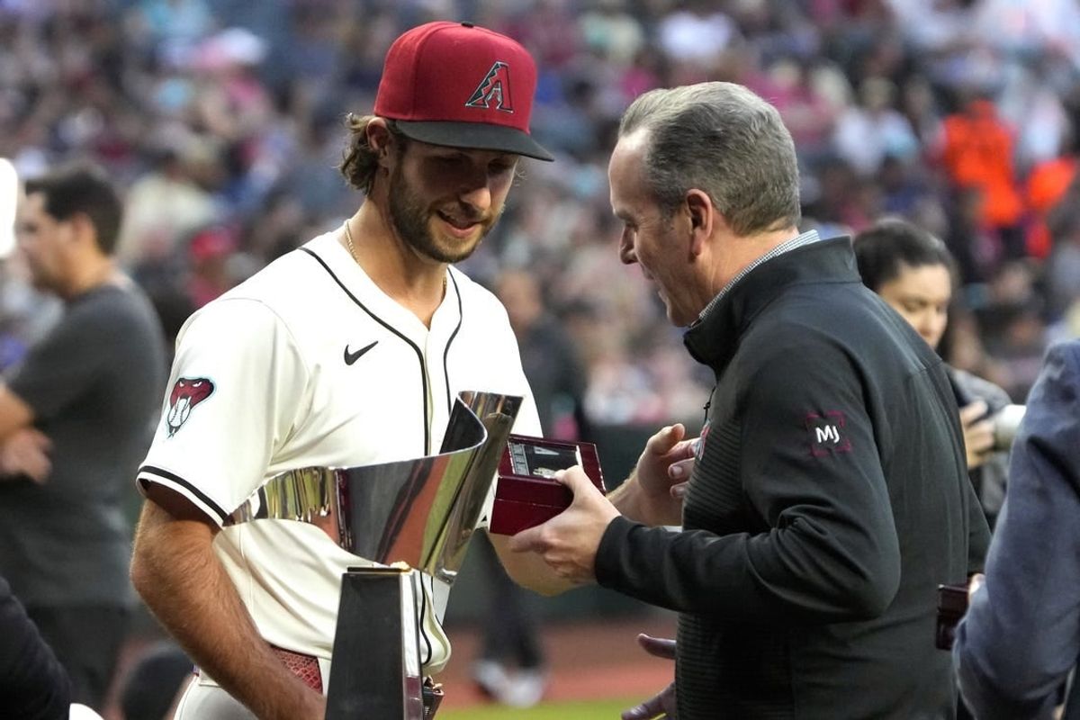 Mar 29, 2024; Phoenix, Arizona, USA; Arizona Diamondbacks President/CEO Derrick Hall presents pitcher Zac Gallen (23) a National League Championship Ring before a game against the Colorado Rockies at Chase Field.