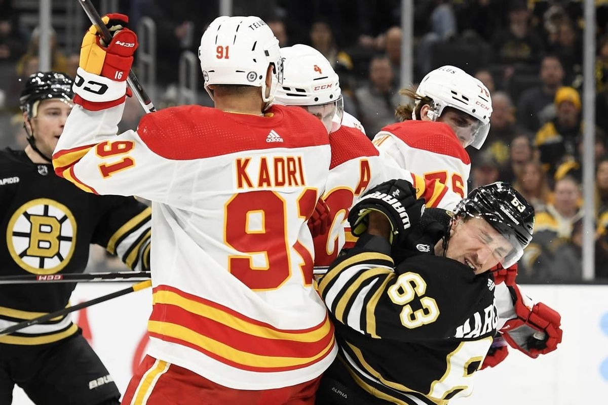 Feb 6, 2024; Boston, Massachusetts, USA; Boston Bruins left wing Brad Marchand (63) reacts after getting a cross check in the face by Calgary Flames center Martin Pospisil (76) during the first period at TD Garden.