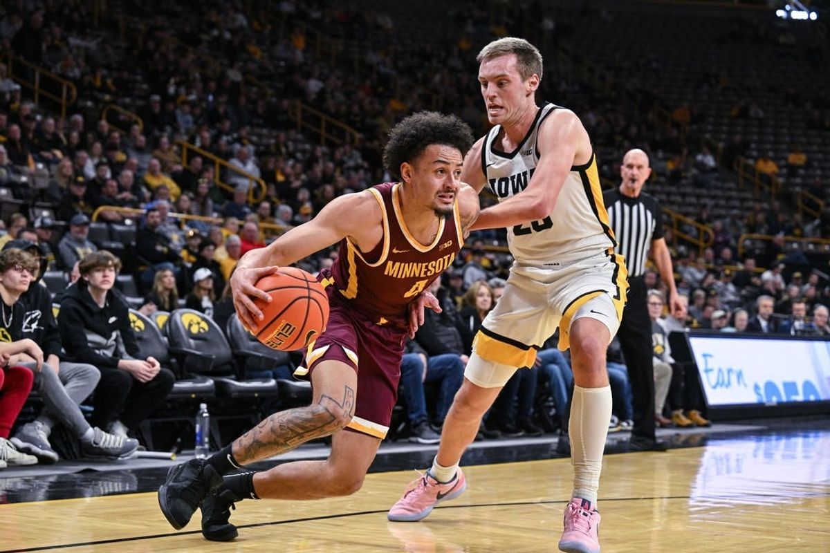 Feb 11, 2024; Iowa City, Iowa, USA; Minnesota Golden Gophers guard Braeden Carrington (4) goes to the basket as Iowa Hawkeyes forward Payton Sandfort (20) defends during the first half at Carver-Hawkeye Arena.