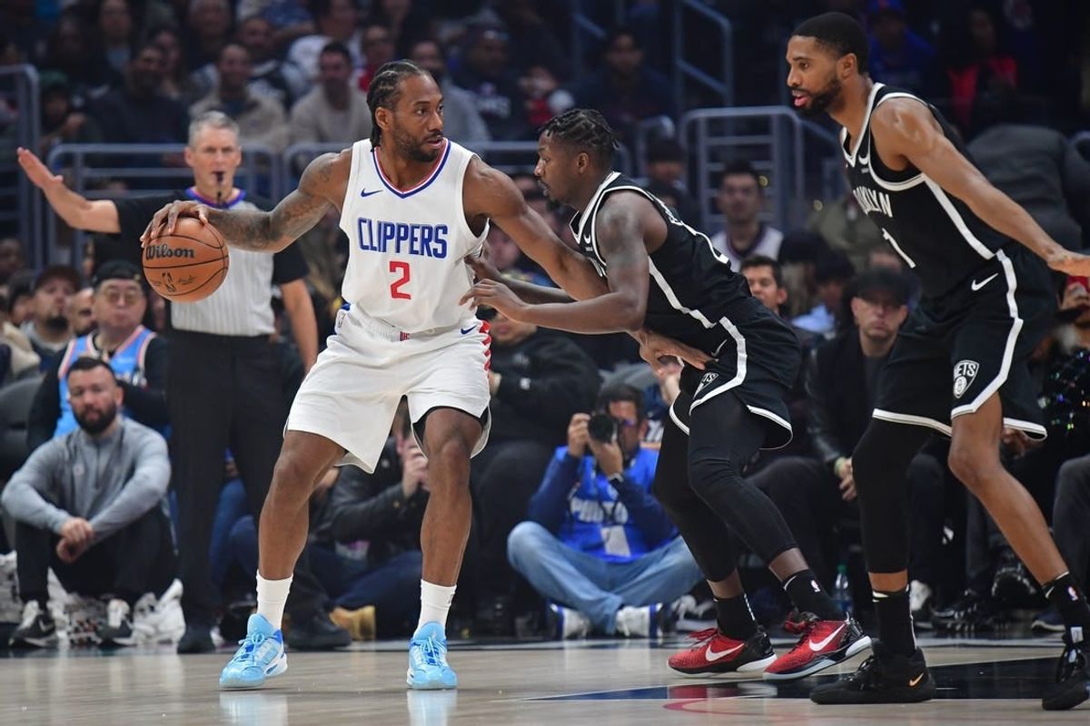 Jan 21, 2024; Los Angeles, California, USA; Los Angeles Clippers forward Kawhi Leonard (2) controls the ball against Brooklyn Nets forward Dorian Finney-Smith (28) and forward Mikal Bridges (1) during the first half at Crypto.com Arena.