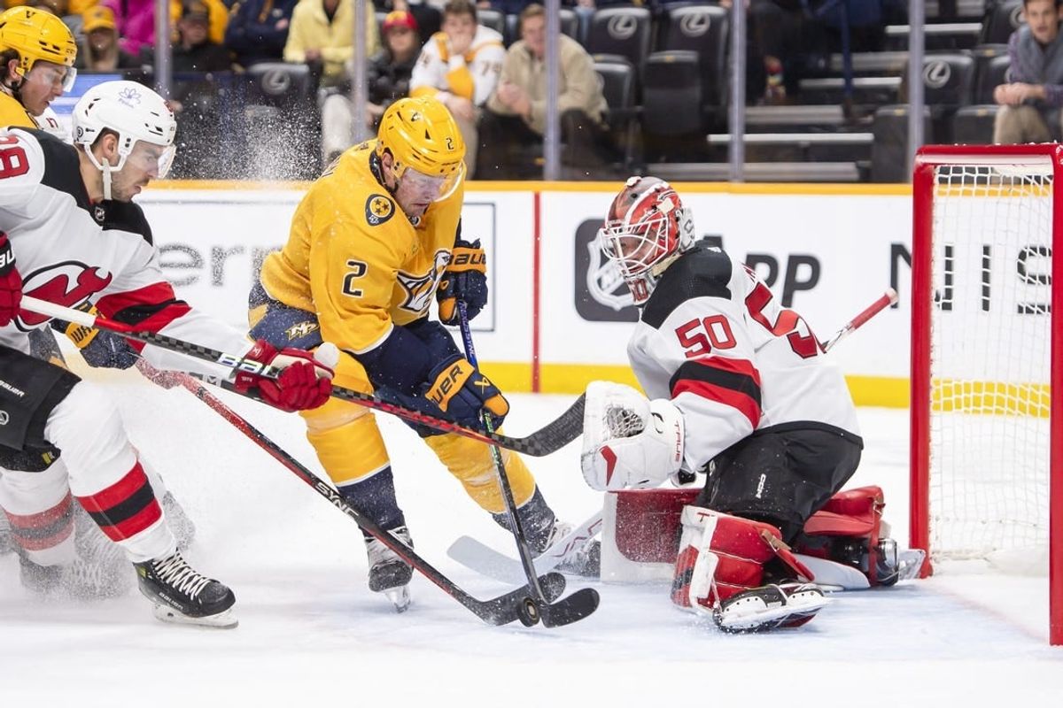 Feb 13, 2024; Nashville, Tennessee, USA;  New Jersey Devils goaltender Nico Daws (50) blocks the shot of Nashville Predators defenseman Luke Schenn (2) during the first period at Bridgestone Arena.