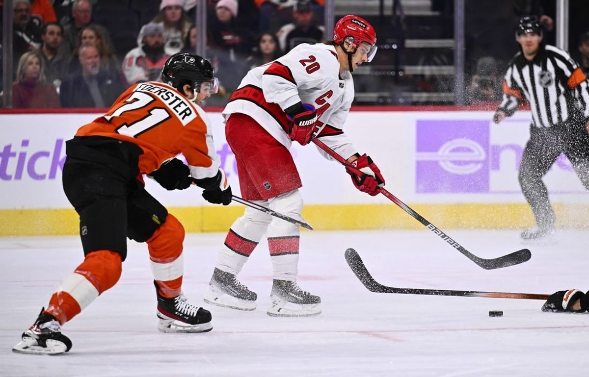 Nov 28, 2023; Philadelphia, Pennsylvania, USA; Carolina Hurricanes center Sebastian Aho (20) reaches for the puck against Philadelphia Flyers right wing Tyson Foerster (71) in the first period at Wells Fargo Center.