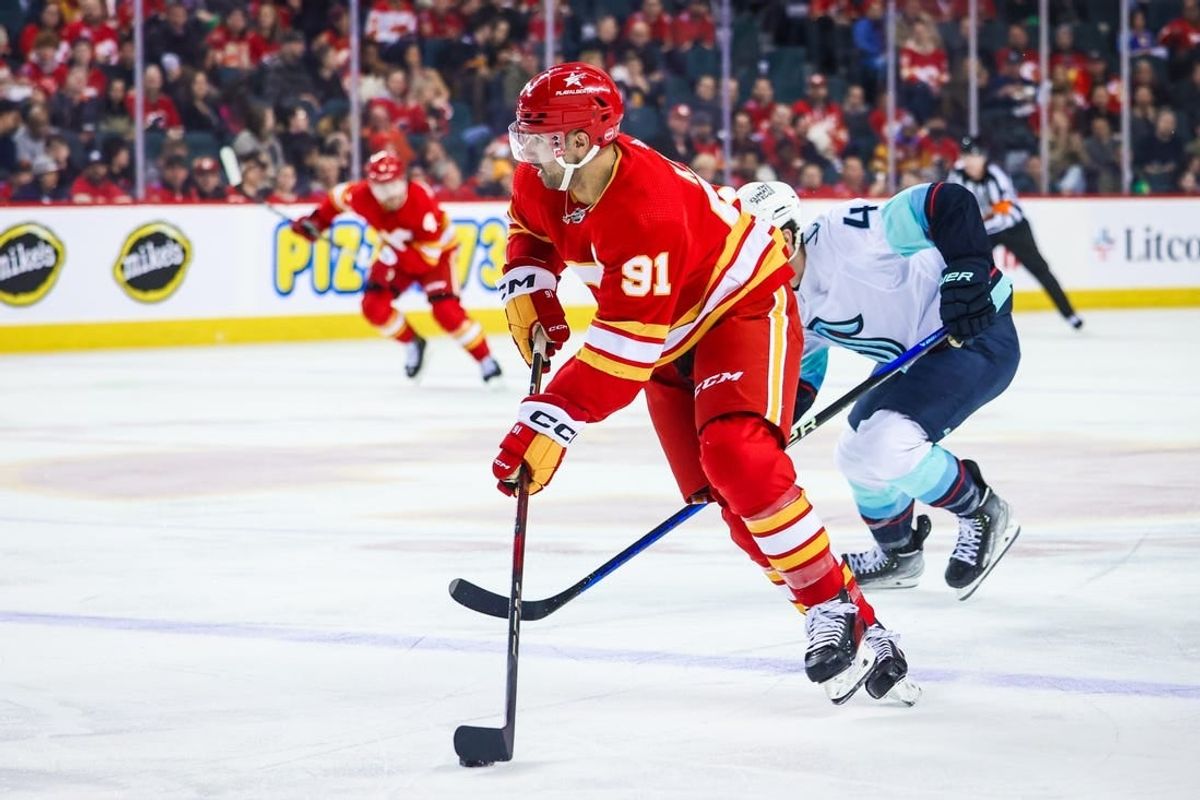 Mar 4, 2024; Calgary, Alberta, CAN; Calgary Flames center Nazem Kadri (91) controls the puck against the Seattle Kraken during the second period at Scotiabank Saddledome.