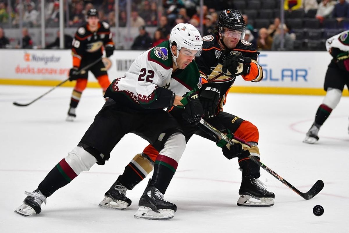 Dec 29, 2023; Anaheim, California, USA; Arizona Coyotes center Jack McBain (22) moves the puck against Anaheim Ducks defenseman Jamie Drysdale (6) during the first period at Honda Center.