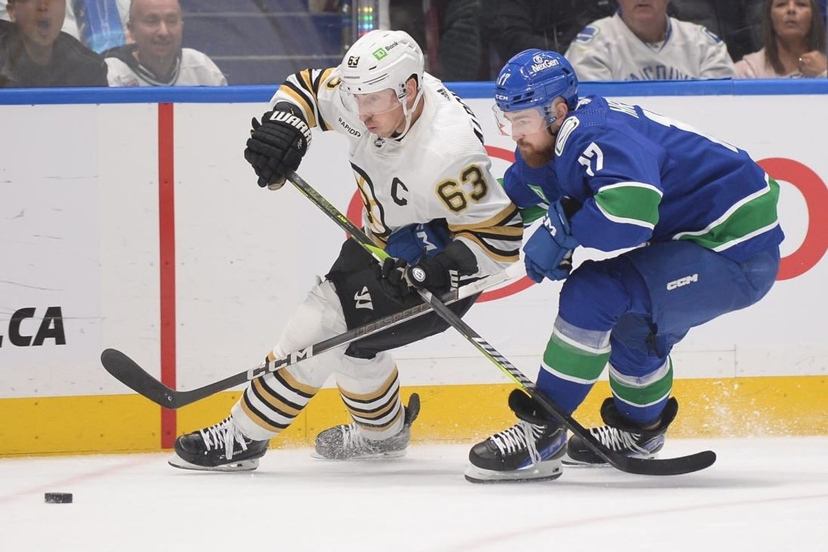 Feb 24, 2024; Vancouver, British Columbia, CAN;  Vancouver Canucks defenseman Filip Hronek (17) checks Boston Bruins forward Brad Marchand (63) during the second period at Rogers Arena.