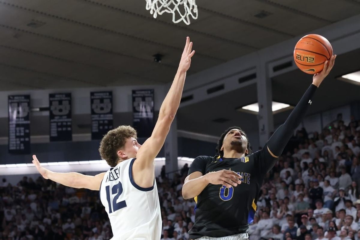 Jan 30, 2024; Logan, Utah, USA; San Jose State Spartans guard Myron Amey Jr. (0) lays the ball up against Utah State Aggies guard Mason Falslev (12) during the first half at Dee Glen Smith Spectrum.
