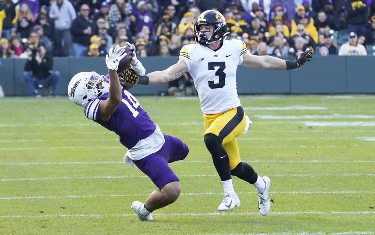 Nov 4, 2023; Chicago, Illinois, USA; Northwestern Wildcats wide receiver Cam Johnson (14) tries to catch a pass as Iowa Hawkeyes defensive back Cooper DeJean (3) defends during the first half at Wrigley Field.