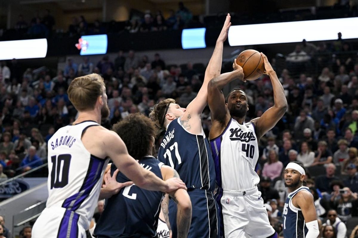 Jan 27, 2024; Dallas, Texas, USA; Sacramento Kings forward Harrison Barnes (40) looks to shoot over Dallas Mavericks guard Luka Doncic (77) during the first quarter at the American Airlines Center.