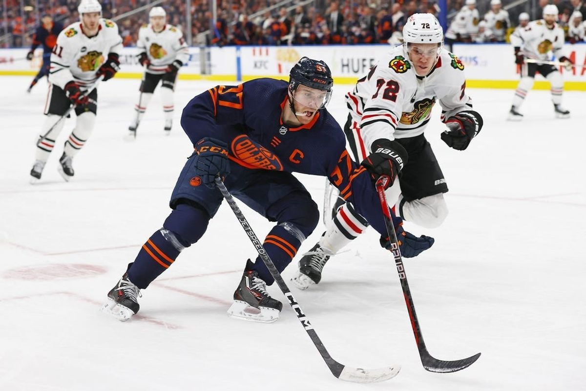Jan 25, 2024; Edmonton, Alberta, CAN; Edmonton Oilers forward Connor McDavid (97) carries the puck around Chicago Blackhawks defensemen Alex Vlasic (72) during the third period at Rogers Place.