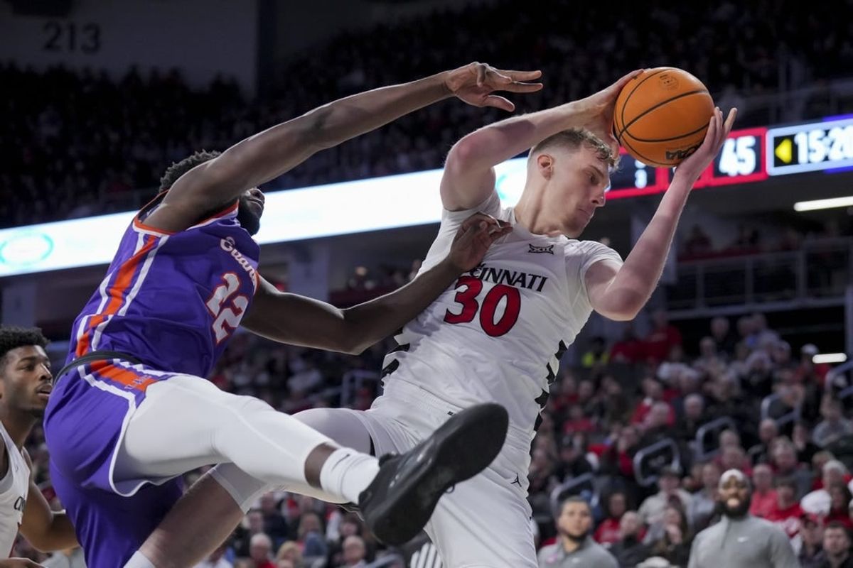 Dec 29, 2023; Cincinnati, Ohio, USA;  Cincinnati Bearcats forward Viktor Lakhin (30) grabs a rebound against Evansville Aces forward Sekou Kalle (22) in the second half at Fifth Third Arena.