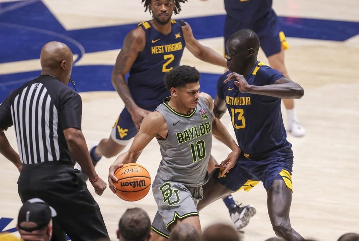 Feb 17, 2024; Morgantown, West Virginia, USA; Baylor Bears guard RayJ Dennis (10) dribbles against West Virginia Mountaineers forward Akok Akok (13) during the second half at WVU Coliseum.