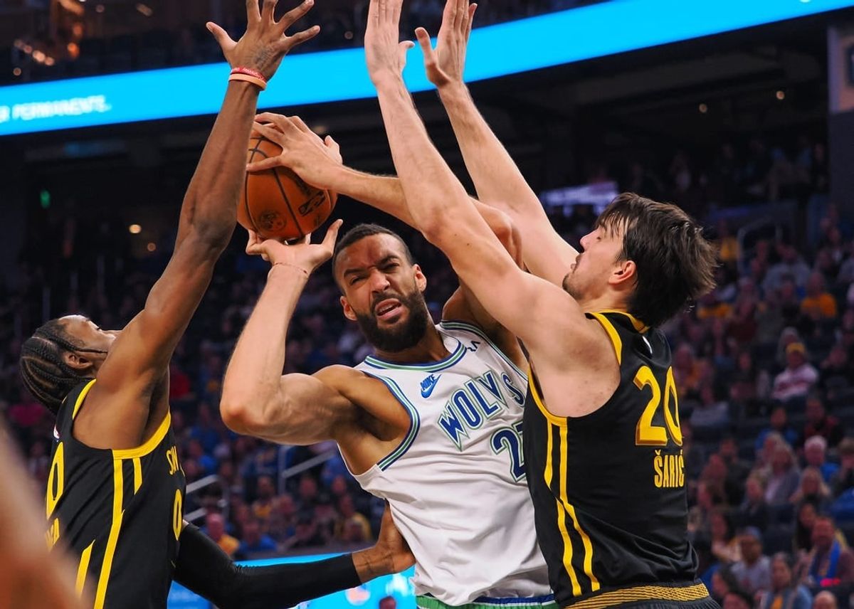 Nov 12, 2023; San Francisco, California, USA; Minnesota Timberwolves center Rudy Gobert (27) controls th ball against Golden State Warriors forward Jonathan Kuminga (00) and forward Dario Saric (20) during the second quarter at Chase Center.