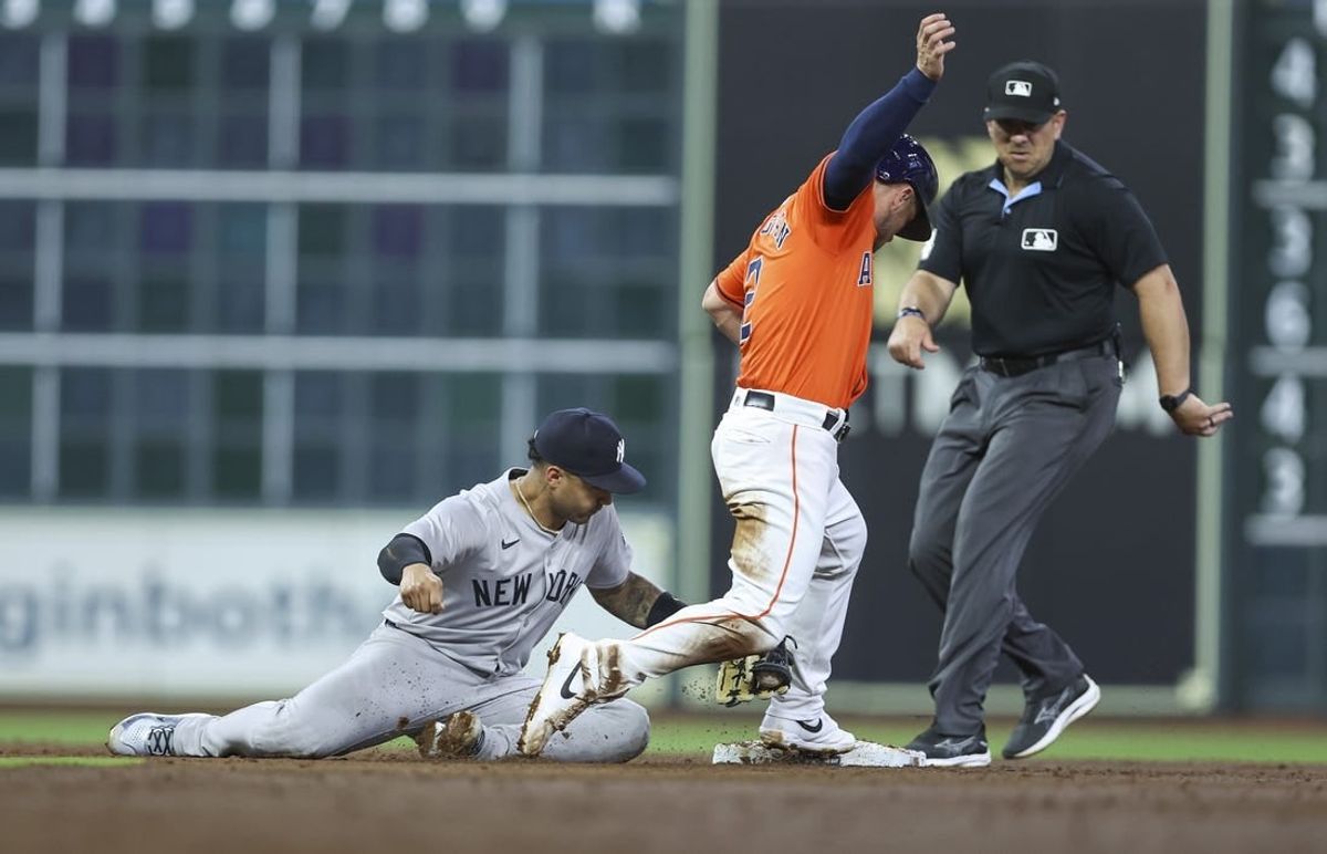 Mar 29, 2024; Houston, Texas, USA; Houston Astros third baseman Alex Bregman (2) is safe at second base as New York Yankees second baseman Gleyber Torres (25) attempts to apply a tag during the third inning at Minute Maid Park.
