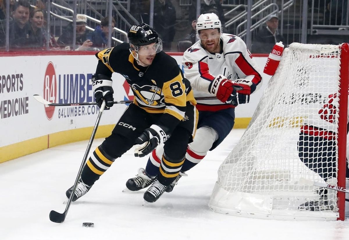 Jan 2, 2024; Pittsburgh, Pennsylvania, USA;  Pittsburgh Penguins center Sidney Crosby (87) moves the puck behind the net as Washington Capitals defenseman Nick Jensen (3) chases during the first period at PPG Paints Arena.