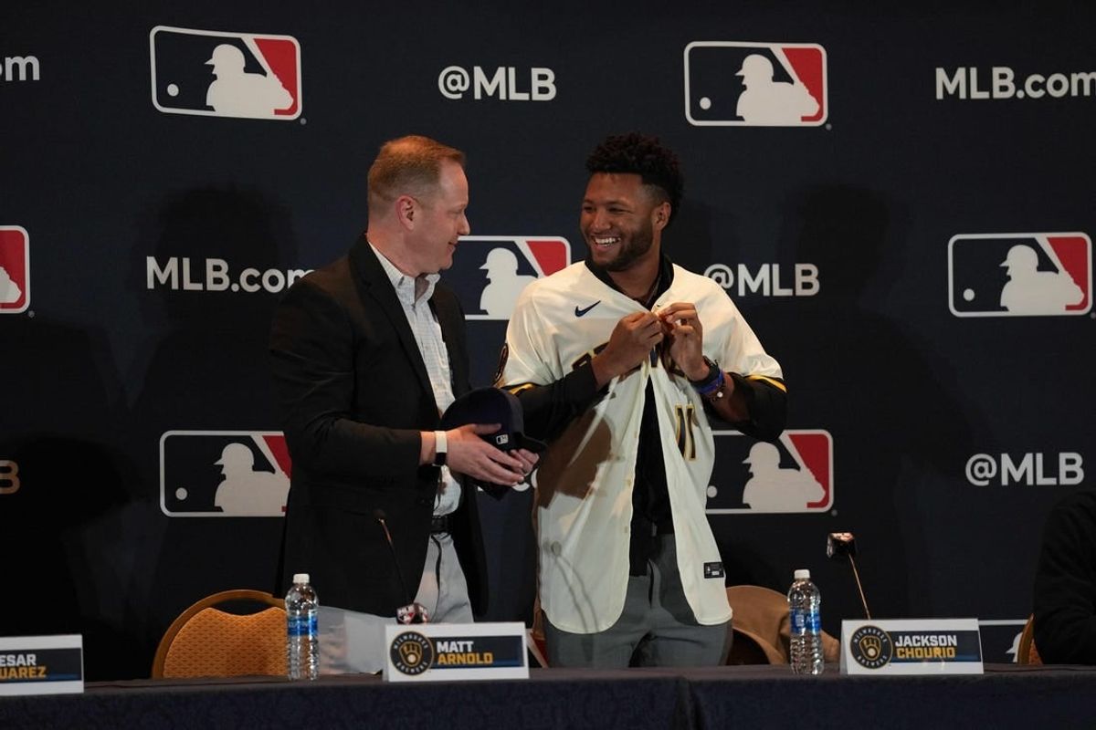 Dec 4, 2023; Nashville, TN, USA; Milwaukee Brewers general manager Matt Arnold presents Jackson Chourio with a team uniform and hat during the MLB 2023 Winter Meetings.