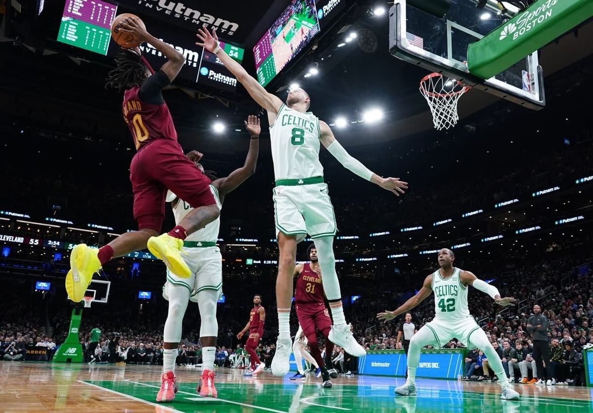 Dec 12, 2023; Boston, Massachusetts, USA; Boston Celtics center Kristaps Porzingis (8) and guard Jrue Holiday (4) defend against Cleveland Cavaliers guard Darius Garland (10) in the second quarter at TD Garden.
