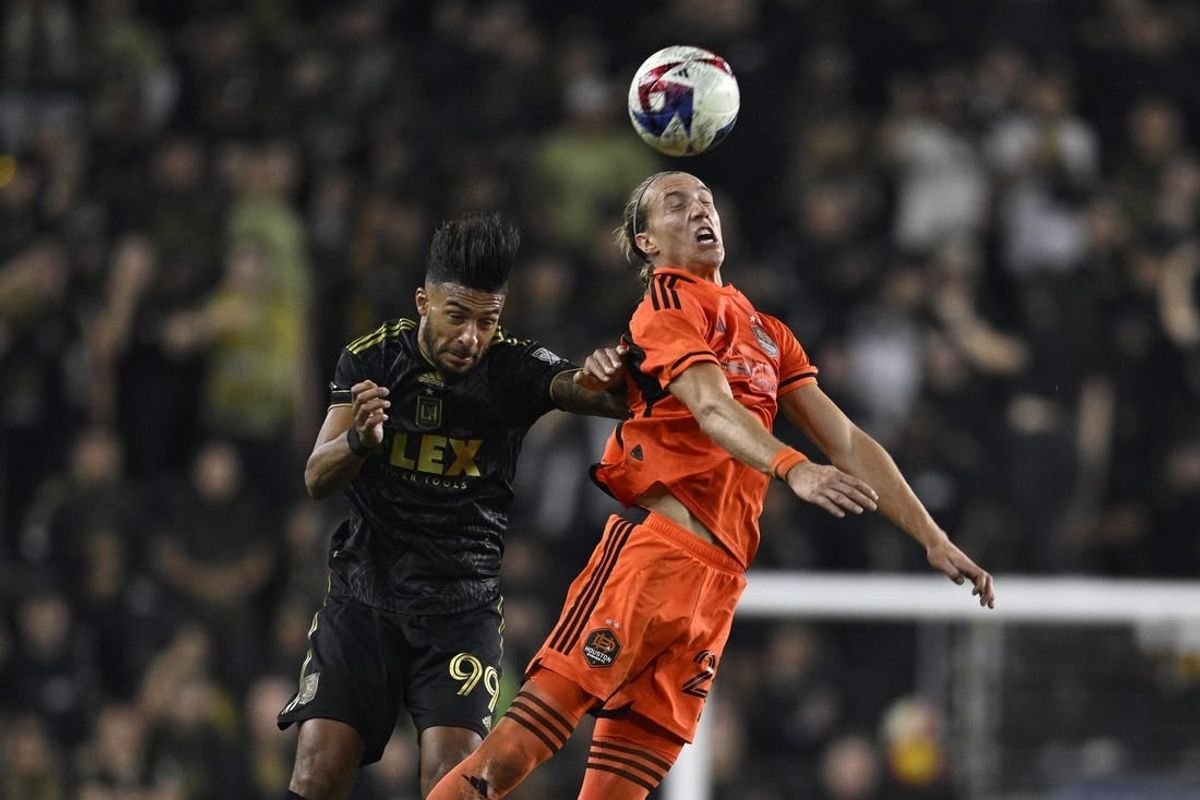 Dec 2, 2023; Los Angeles, California, USA; Houston Dynamo midfielder Griffin Dorsey (25) heads the ball past Los Angeles FC forward Denis Bouanga (99) for the MLS Cup Western Conference Final at BMO Stadium.