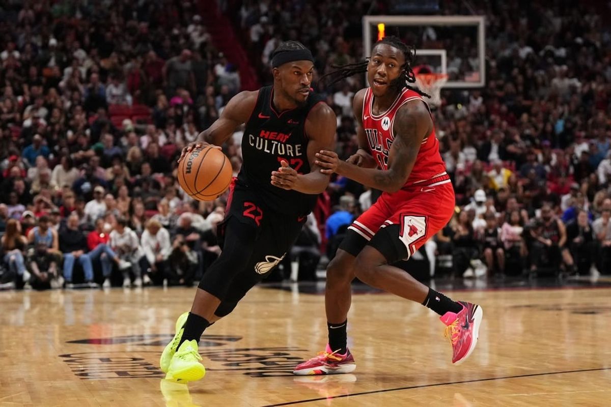 Dec 16, 2023; Miami, Florida, USA; Miami Heat forward Jimmy Butler (22) drives the ball around Chicago Bulls guard Ayo Dosunmu (12) during the second half at Kaseya Center.