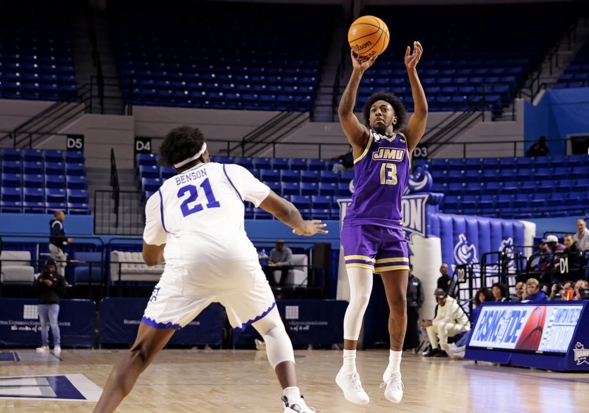 Dec 16, 2023; Hampton, Virginia, USA; James Madison Dukes guard Michael Green III (13) shoots the ball against Hampton Pirates forward Ja'Von Benson (21) during the second half at Hampton Convocation Center.