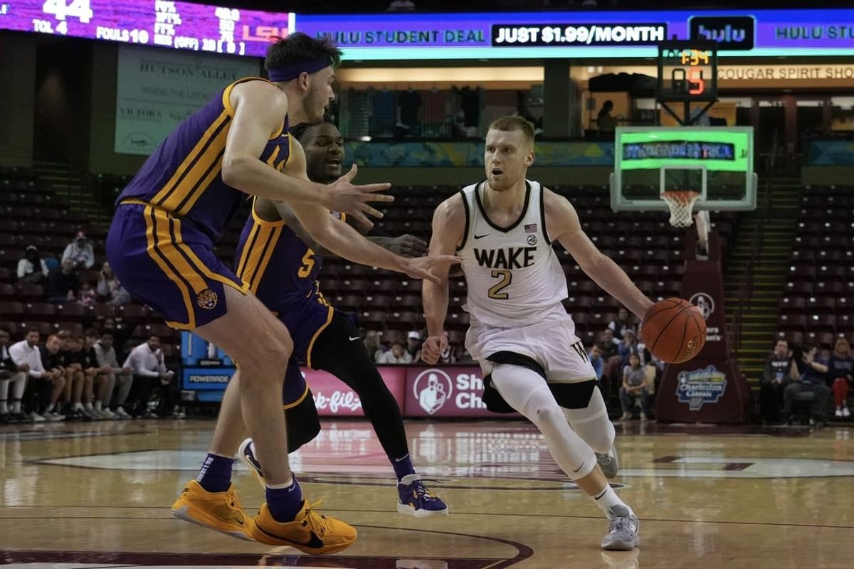 Nov 19, 2023; Charleston, SC, USA; Wake Forest Demon Deacons guard Cameron Hildreth (2) drives the ball around LSU Tigers forward Will Baker (9) in the first half at TD Arena.