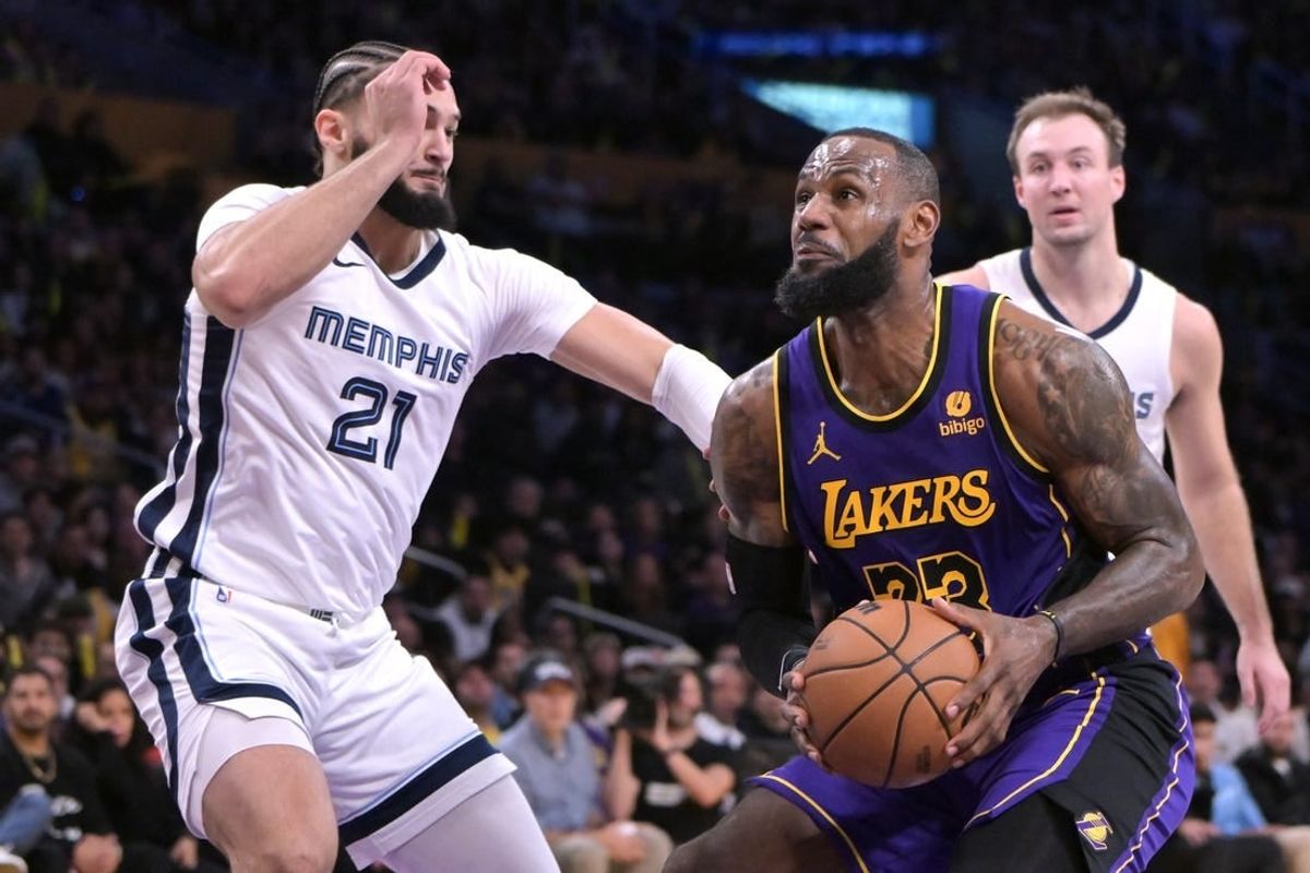 Jan 5, 2024; Los Angeles, California, USA; Los Angeles Lakers forward LeBron James (23) drives to the basket past Memphis Grizzlies forward David Roddy (21) in the first half at Crypto.com Arena.