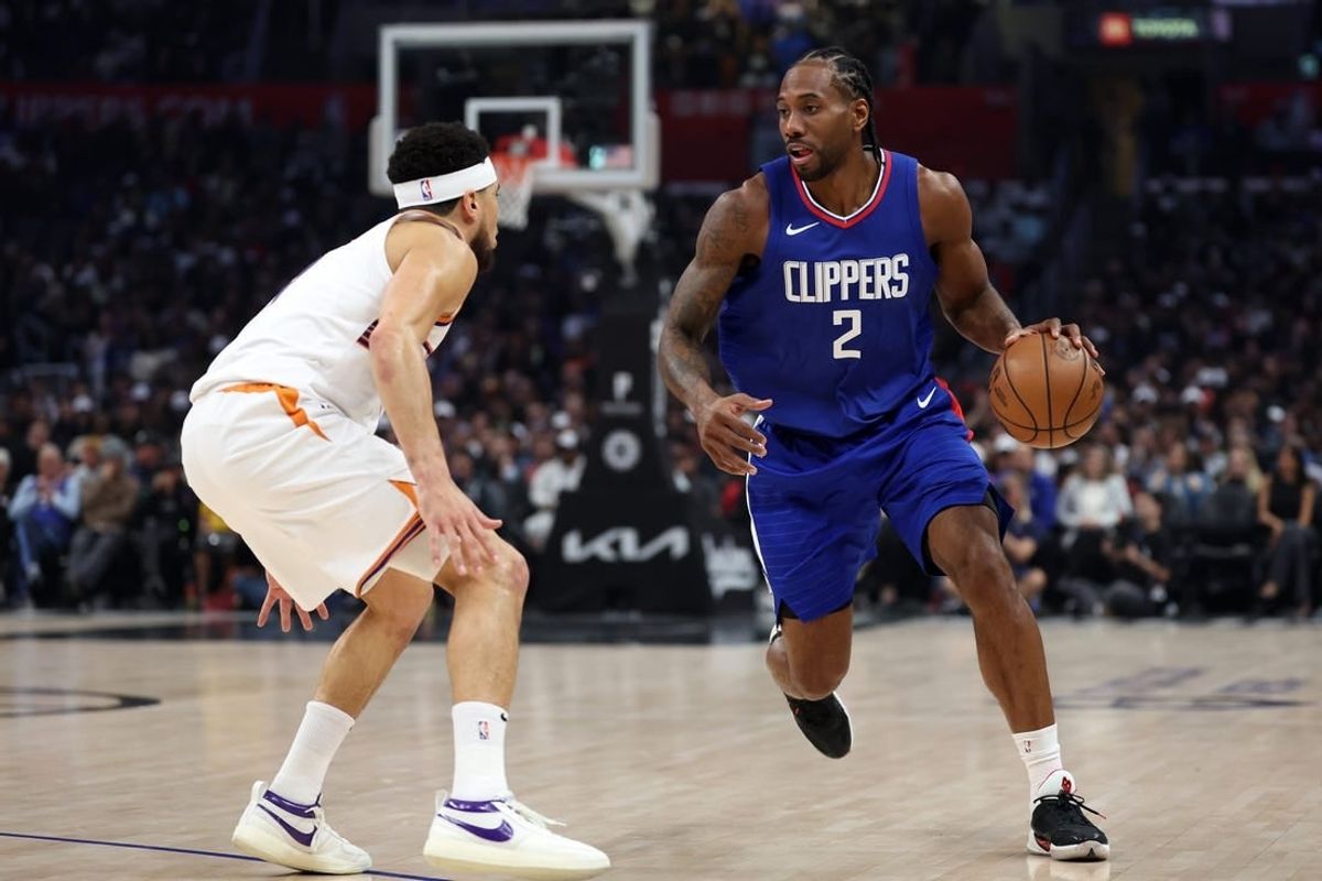 Jan 8, 2024; Los Angeles, California, USA;  Los Angeles Clippers forward Kawhi Leonard (2) dribbles the ball against Phoenix Suns guard Devin Booker (1) during the first quarter at Crypto.com Arena.