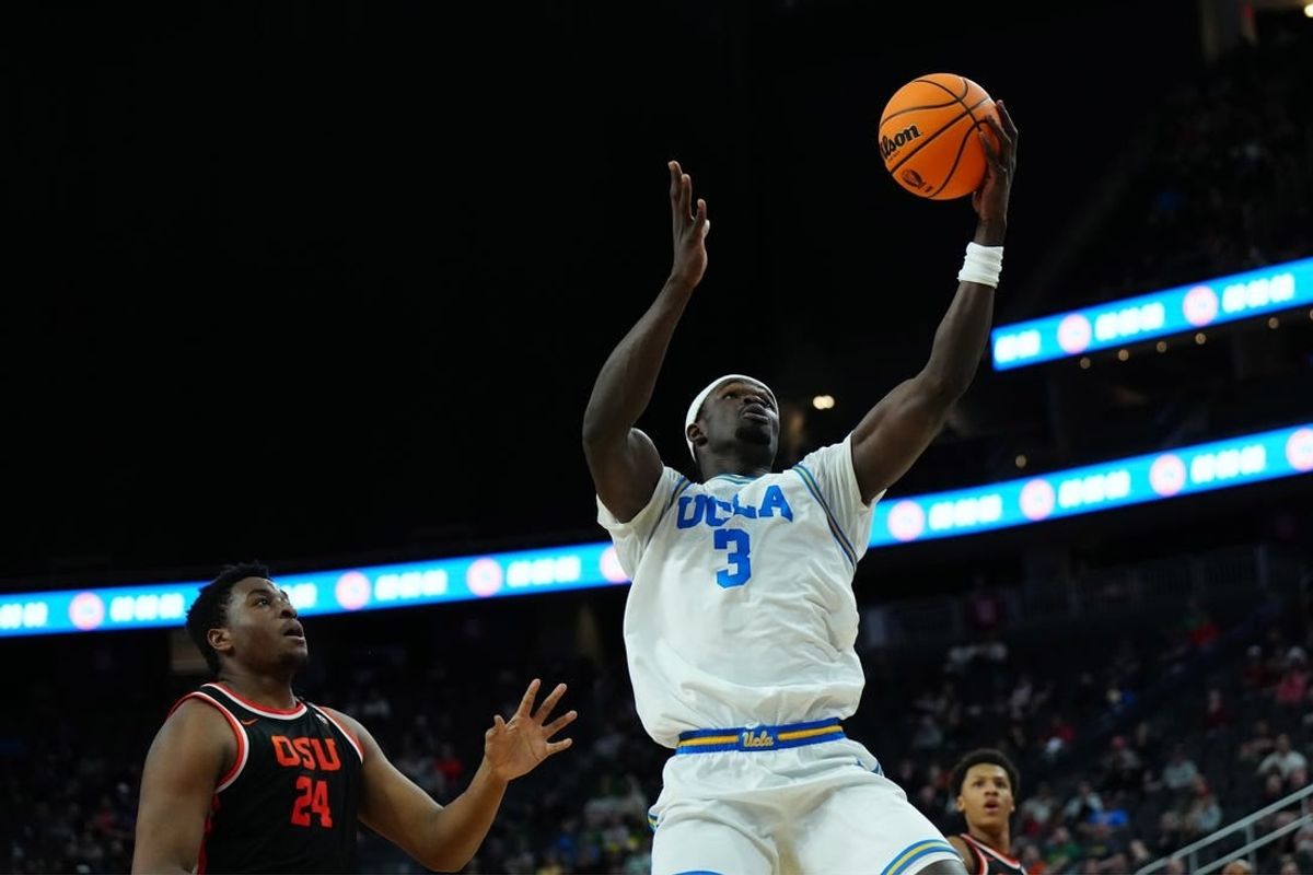 Mar 13, 2024; Las Vegas, NV, USA; UCLA Bruins forward Adem Bona (3) catches the ball against Oregon State Beavers center KC Ibekwe (24) in the first half at T-Mobile Arena.