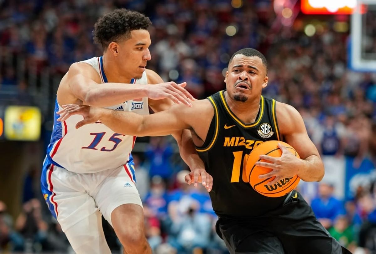 Dec 9, 2023; Lawrence, Kansas, USA; Missouri Tigers guard Nick Honor (10) drives against Kansas Jayhawks guard Kevin McCullar Jr. (15) during the first half at Allen Fieldhouse.