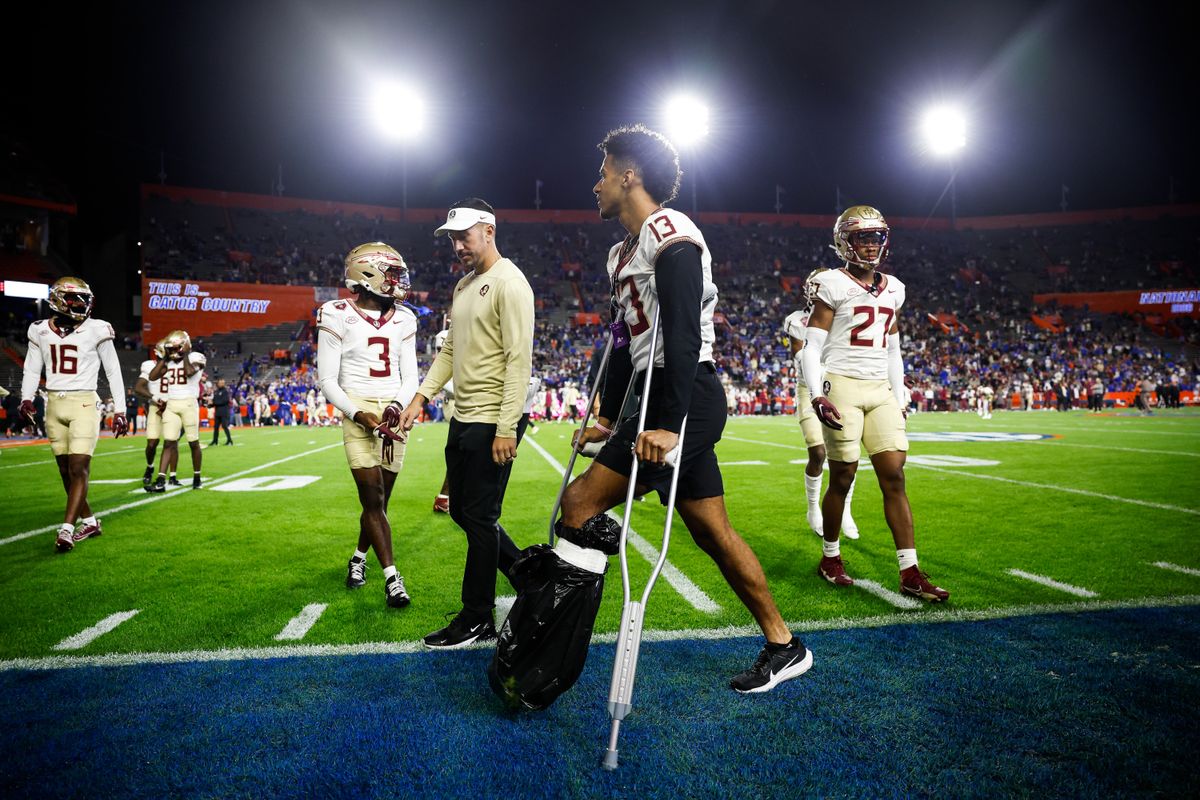 Jordan Travis #13 of the Florida State Seminoles walks with crutches before the start of a game against the Florida Gators at Ben Hill Griffin Stadium on November 25, 2023 in Gainesville, Florida.
