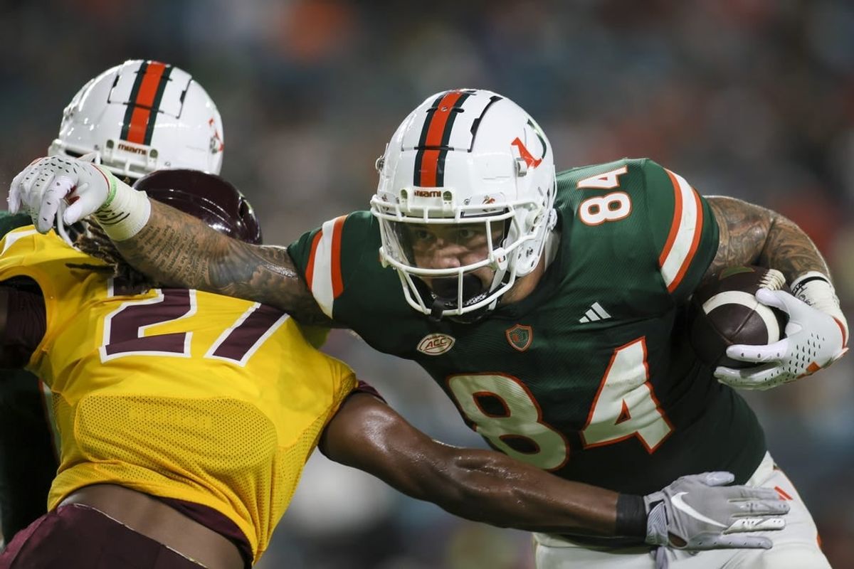 Sep 14, 2023; Miami Gardens, Florida, USA; Miami Hurricanes tight end Cam McCormick (84) runs with the football against Bethune Cookman Wildcats cornerback Stephen Sparrow (27) during the first quarter at Hard Rock Stadium.