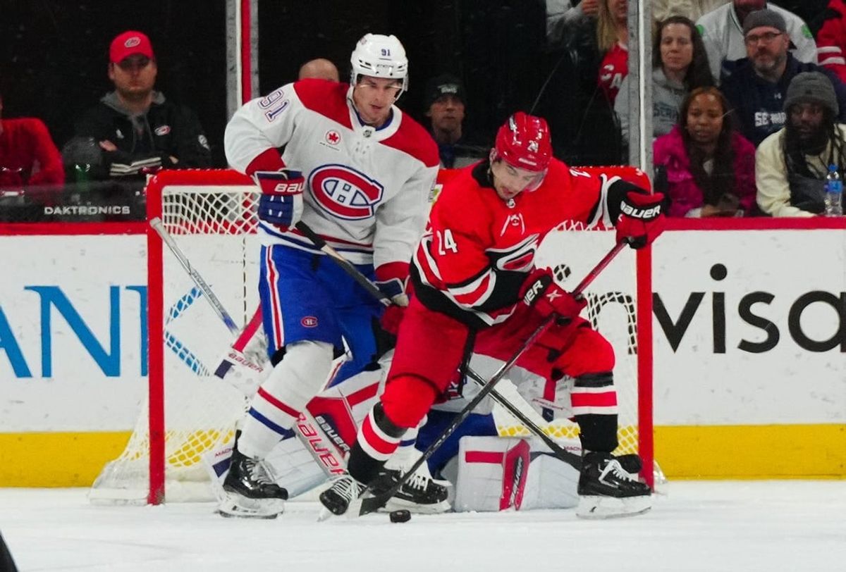 Dec 28, 2023; Raleigh, North Carolina, USA; Carolina Hurricanes center Seth Jarvis (24) and Montreal Canadiens center Sean Monahan (91) watch the shot during the second period at PNC Arena.