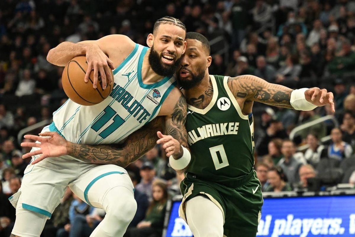 Feb 9, 2024; Milwaukee, Wisconsin, USA; Charlotte Hornets forward Cody Martin (11) drives to the basket against Milwaukee Bucks guard Damian Lillard (0) in the first half at Fiserv Forum.