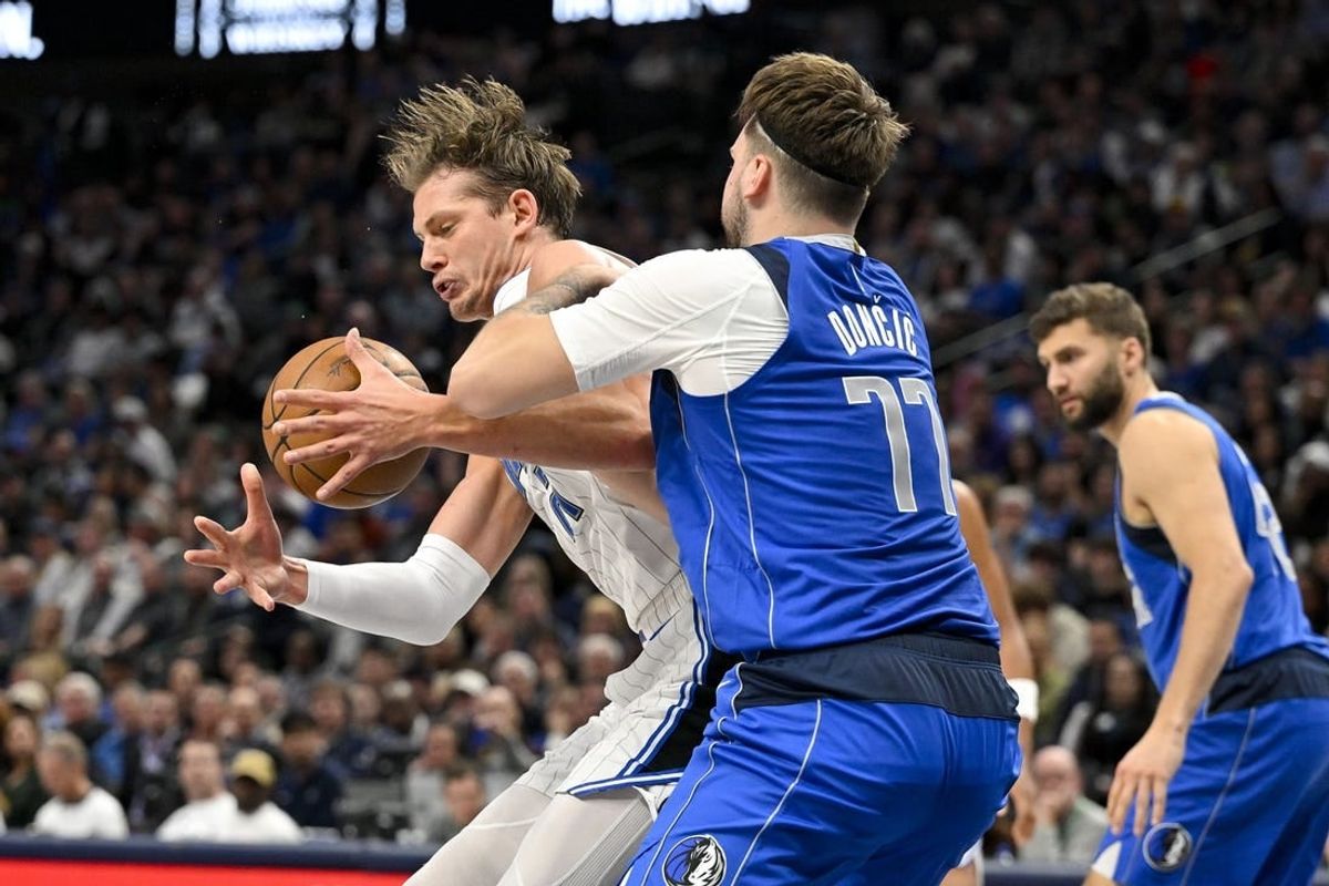 Jan 29, 2024; Dallas, Texas, USA; Dallas Mavericks guard Luka Doncic (77) attempts to knock the ball away from Orlando Magic center Moritz Wagner (21) during the second quarter at the American Airlines Center.
