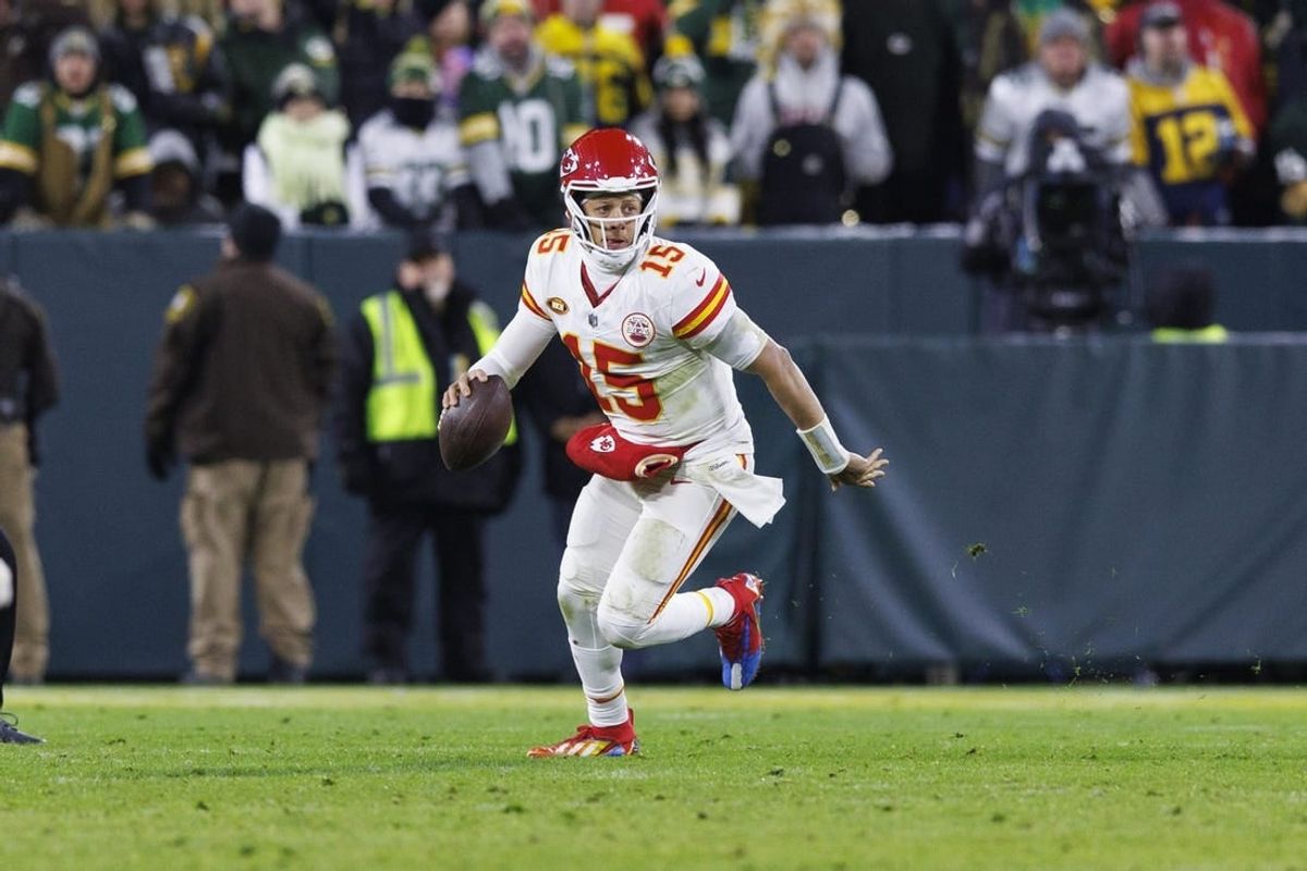 Dec 3, 2023; Green Bay, Wisconsin, USA;  Kansas City Chiefs quarterback Patrick Mahomes (15) scrambles with the football during the fourth quarter against the Green Bay Packers at Lambeau Field.