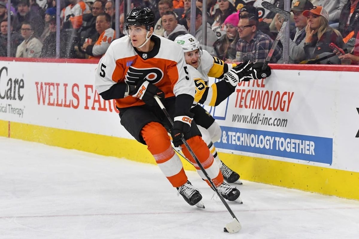 Jan 8, 2024; Philadelphia, Pennsylvania, USA; Philadelphia Flyers defenseman Egor Zamula (5) carries the puck past Pittsburgh Penguins center Noel Acciari (55) during the second period at Wells Fargo Center.