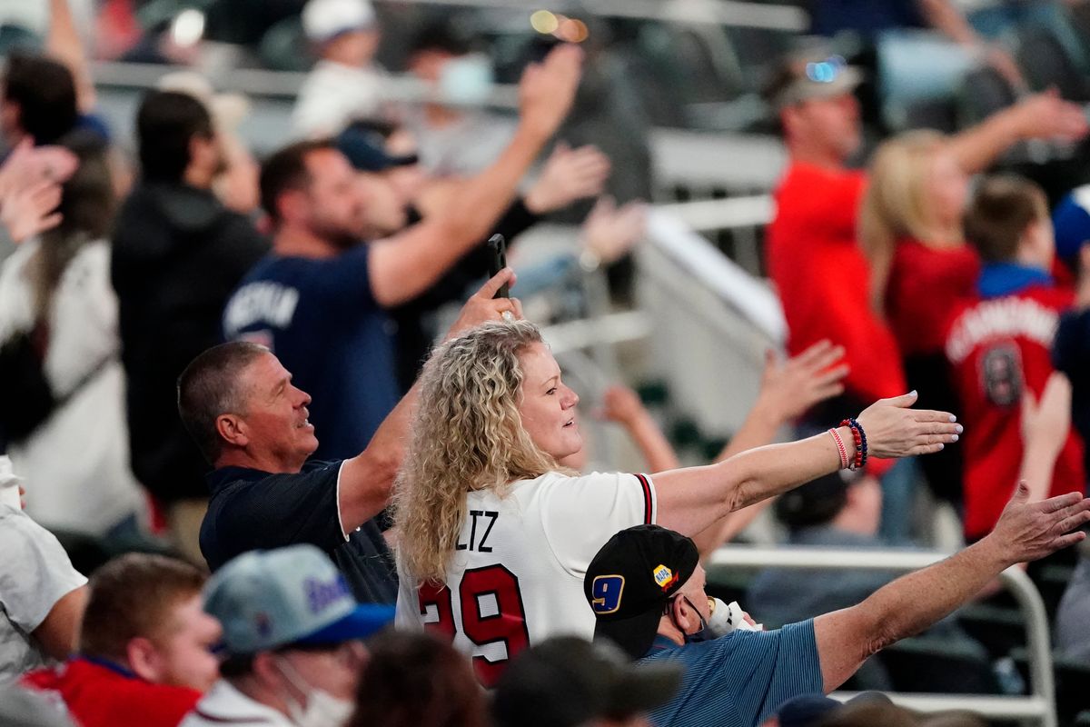 Braves fans perform the team’s trademark “Tomahawk Chop”.