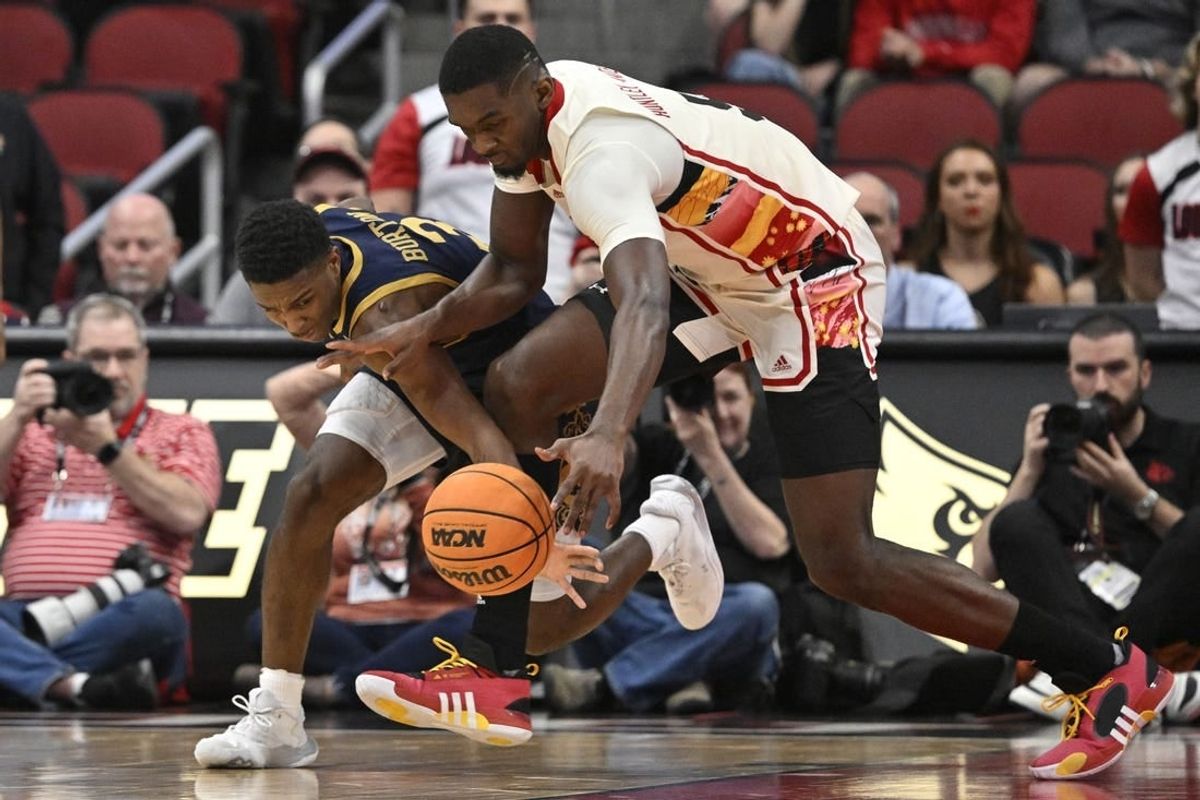 Feb 21, 2024; Louisville, Kentucky, USA; Notre Dame Fighting Irish guard Markus Burton (3) scrambles for a loose ball with Louisville Cardinals forward Brandon Huntley-Hatfield (5) during the first half at KFC Yum! Center.