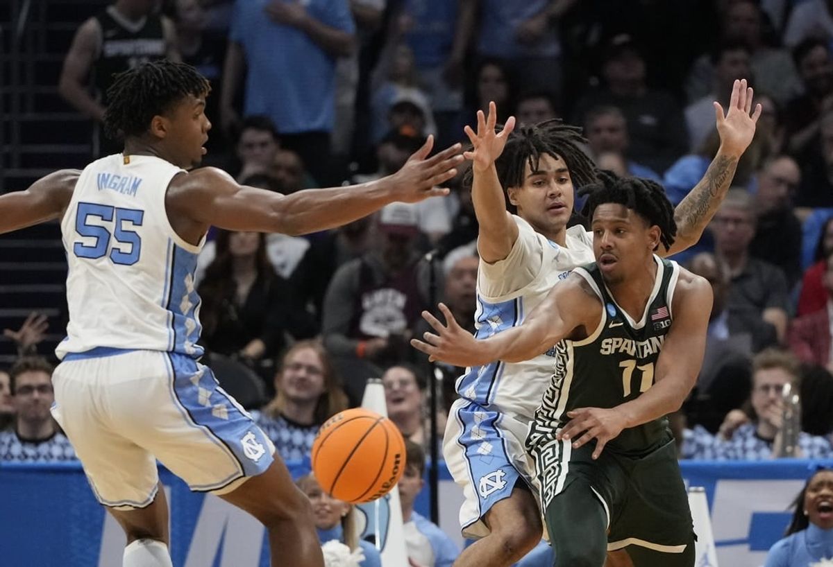 March 23, 2024, Charlotte, NC, USA; Michigan State Spartans guard A.J. Hoggard (11) passes away from North Carolina Tar Heels forward Harrison Ingram (55) and North Carolina Tar Heels guard Elliot Cadeau (2)  in the second round of the 2024 NCAA Tournament at the Spectrum Center.