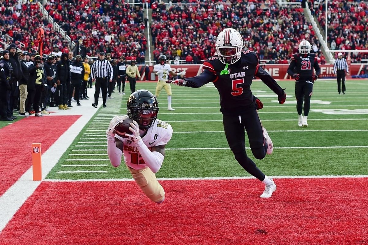 Nov 25, 2023; Salt Lake City, Utah, USA; Colorado Buffaloes athlete Travis Hunter (12) dives for a catch in the end zone in front of Utah Utes cornerback Zemaiah Vaughn (5) at Rice-Eccles Stadium.