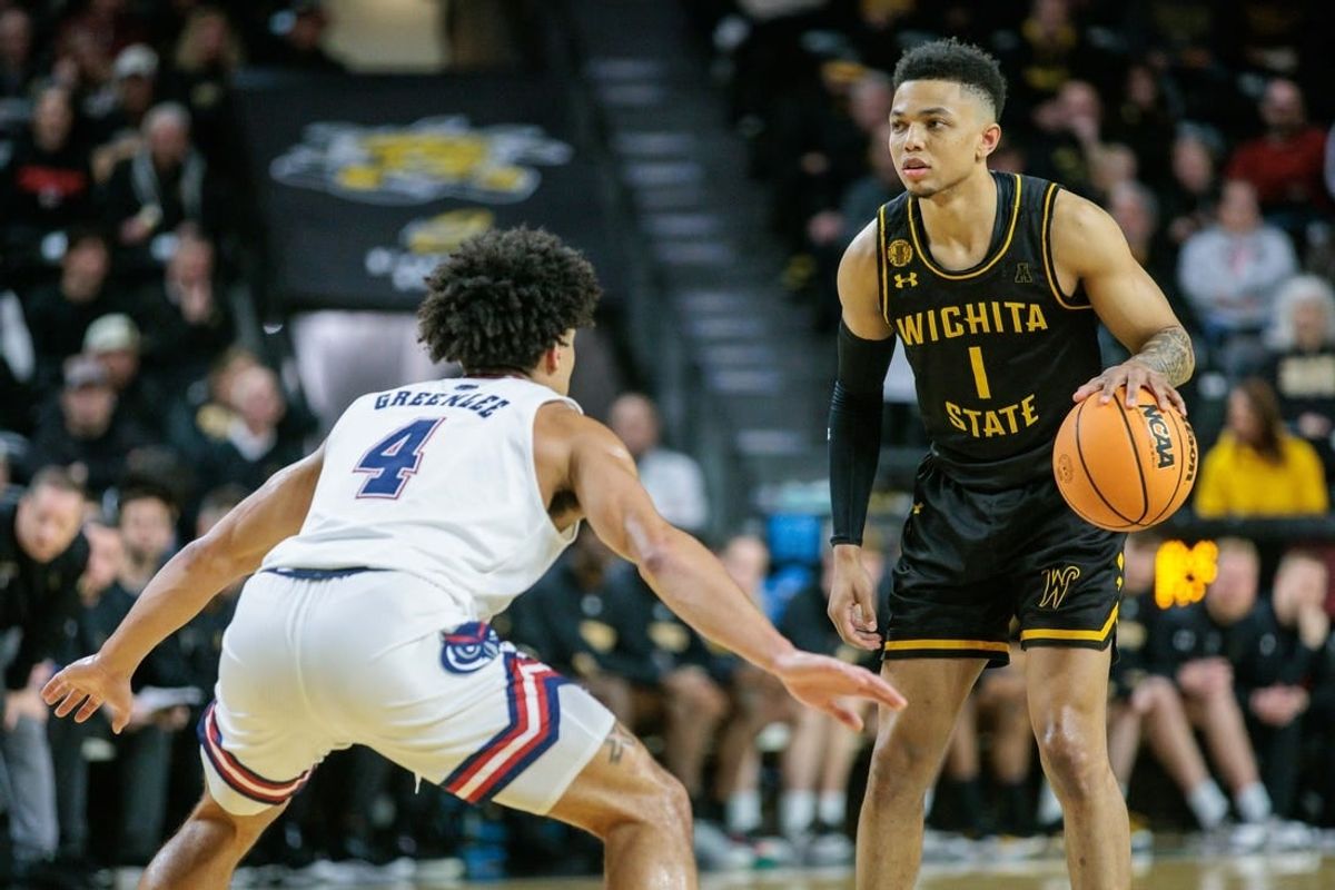 Feb 11, 2024; Wichita, Kansas, USA; Wichita State Shockers guard Xavier Bell (1) dribbles the ball against Florida Atlantic Owls guard Bryan Greenlee (4) during the first half at Charles Koch Arena.