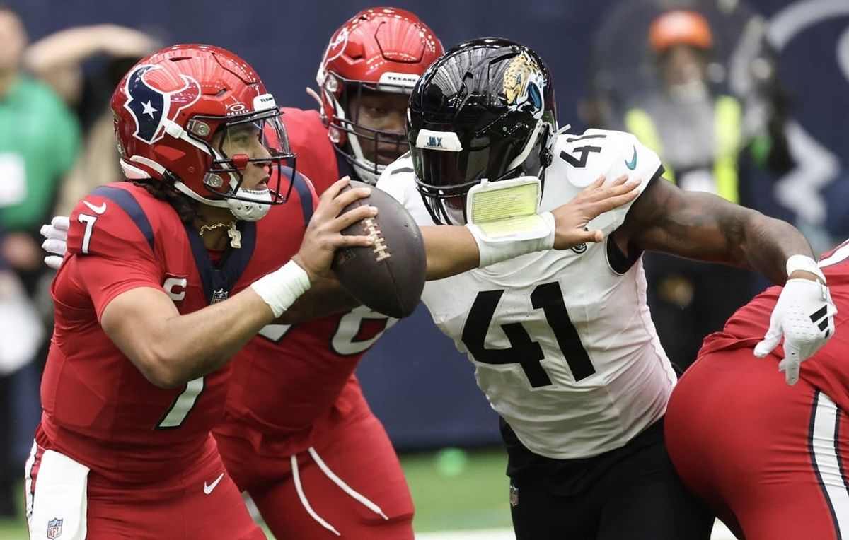 Nov 26, 2023; Houston, Texas, USA; Houston Texans quarterback C.J. Stroud (7) scrambles from Jacksonville Jaguars linebacker Josh Allen (41) in the first quarter at NRG Stadium.