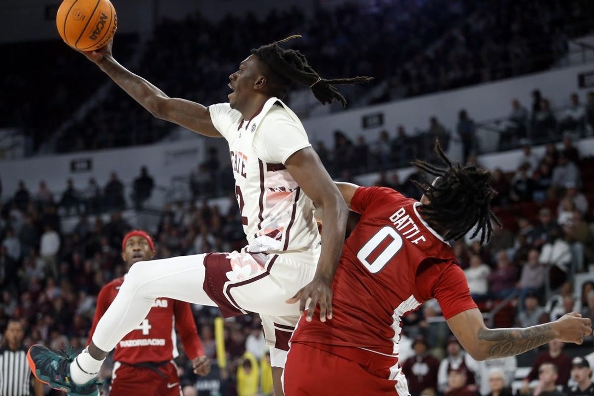 Feb 17, 2024; Starkville, Mississippi, USA; Mississippi State Bulldogs forward KeShawn Murphy (12) collects a rebound over Arkansas Razorbacks guard Khalif Battle (0) during the first half at Humphrey Coliseum.