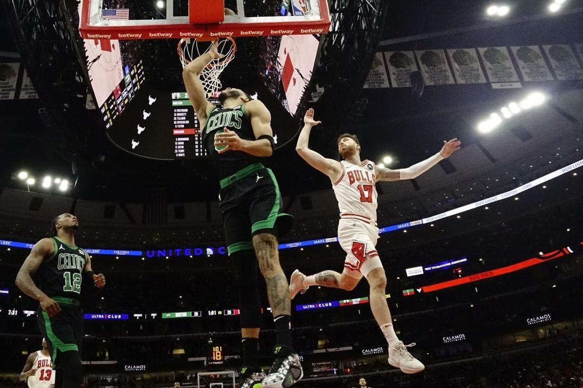 Mar 23, 2024; Chicago, Illinois, USA; Boston Celtics forward Jayson Tatum (0) scores on Chicago Bulls forward Onuralp Bitim (17) during the first quarter at United Center.