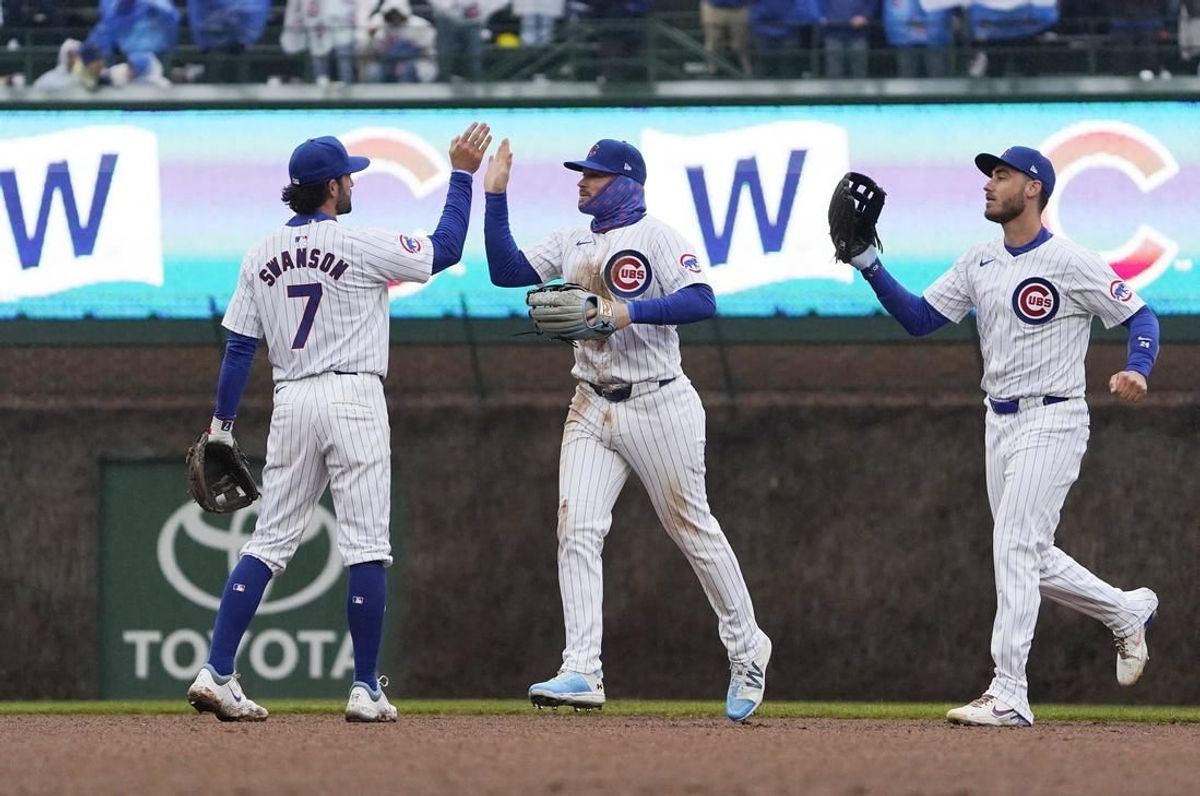 Apr 1, 2024; Chicago, Illinois, USA; Chicago Cubs shortstop Dansby Swanson (7), left fielder Ian Happ (8), and center fielder Cody Bellinger (24) celebrate their win against the Colorado Rockies at Wrigley Field.