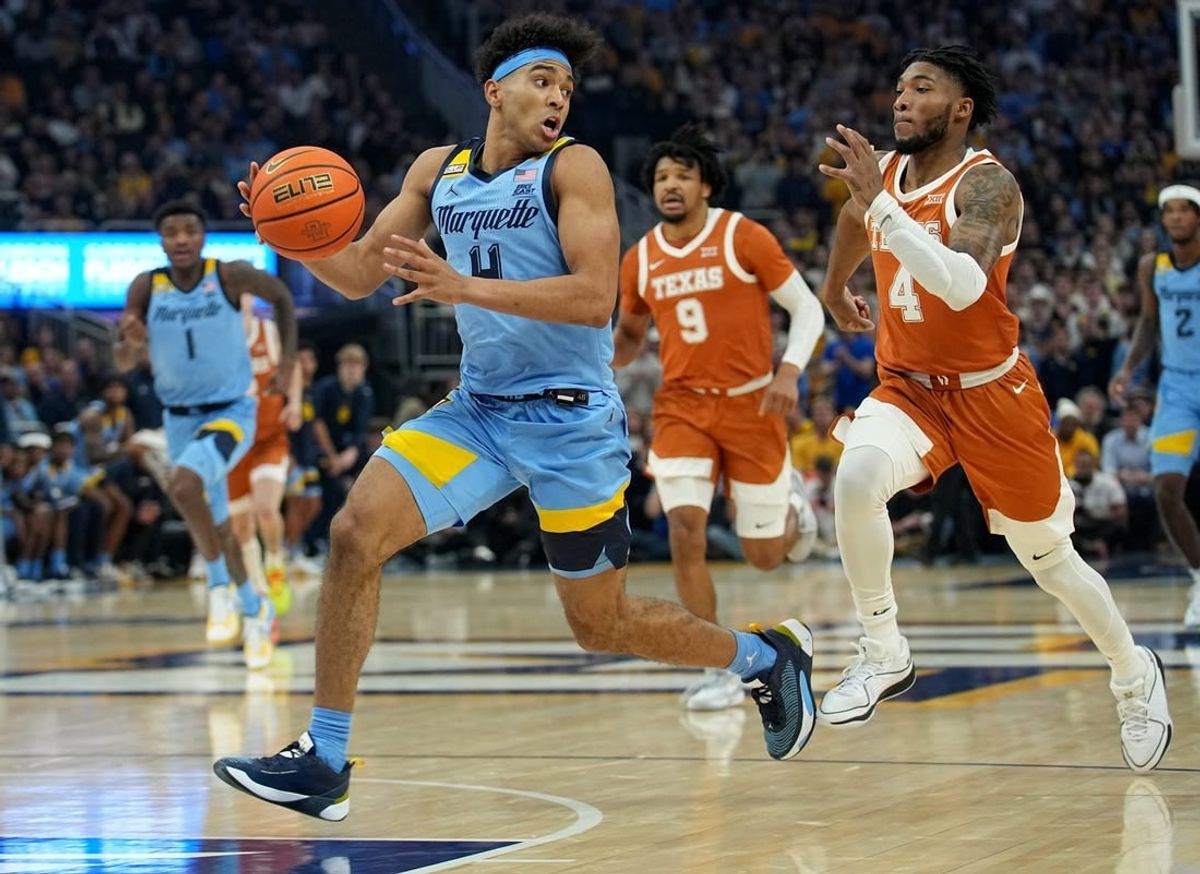 Dec 6, 2023; Milwaukee, Wisconsin, USA;  Marquette guard Stevie Mitchell (4)  gets past Texas guard Tyrese Hunter (4) on a fast break during the first half of their game at Fiserv Forum.